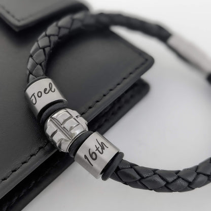Personalised black leather bracelet with engraved Joel name and 16th birthday rings