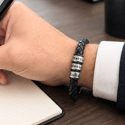 Man wearing black braided leather bracelet with engraved stainless steel name rings