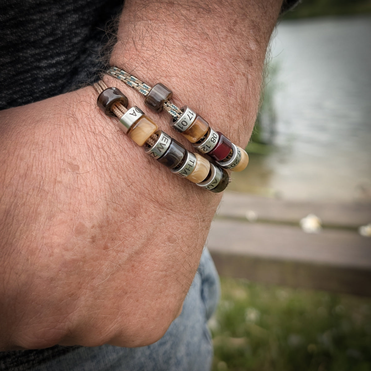 Men’s personalised cord bracelet with engraved beads worn on the wrist