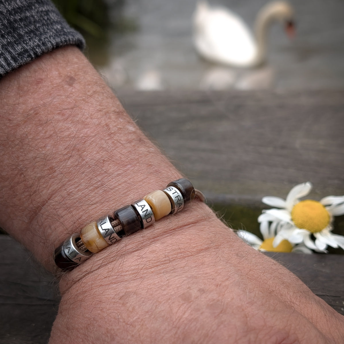 Men’s personalised cord bracelet with custom engraved beads worn on the wrist