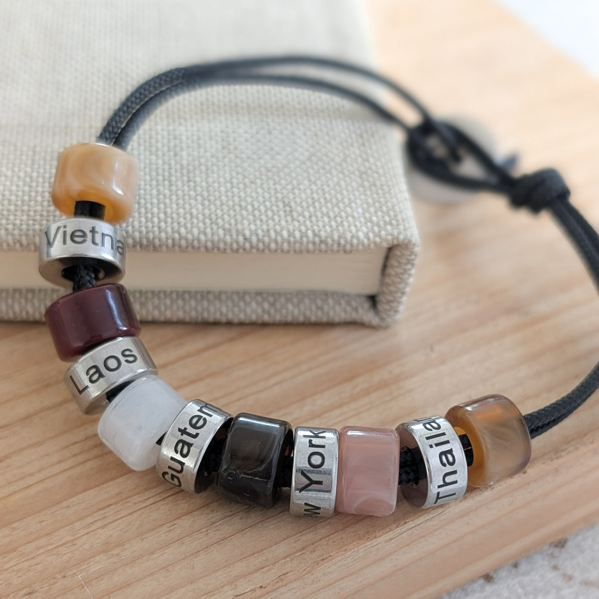 Men’s personalised travel bracelet with engraved beads featuring memorable places