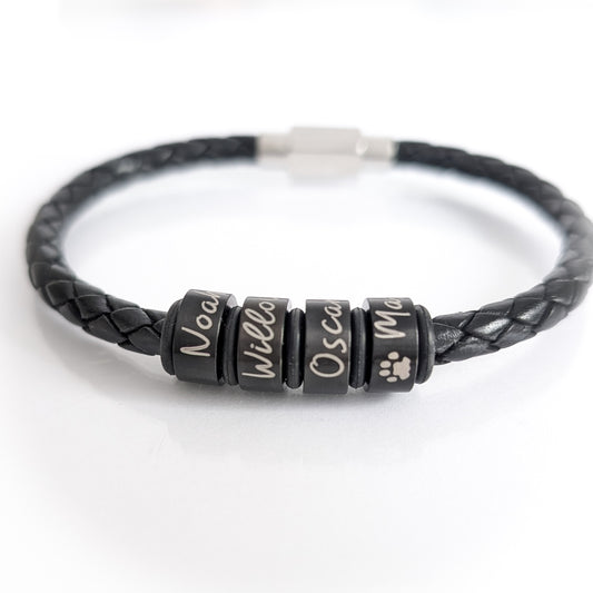 Personalised men's black leather bracelet with small black engraved name rings